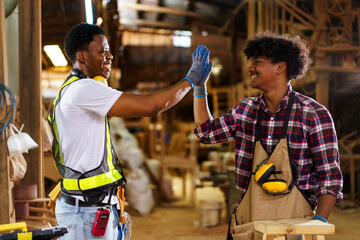 Two professional African carpenters are working together in sawmill or workshop.