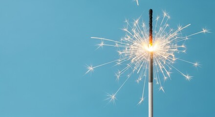 A single sparkler emitting bright light against a pastel azure background