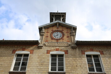 Façade d'école en brique avec horloge ancienne