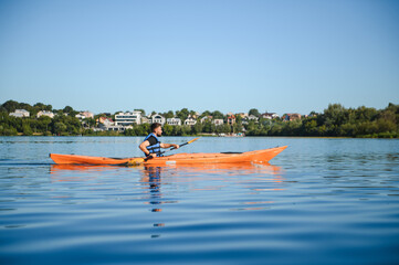 Kayaker paddling on calm lake enjoying water sports and active recreation