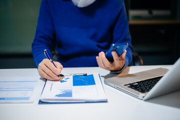 business documents on office desk with laptop and smart phone and graph business diagram and man...