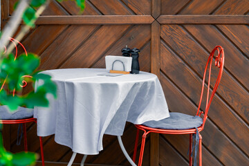 interior cafe patio space furniture chair and table white sheet garden floral decorative elements bokeh foreground view for people