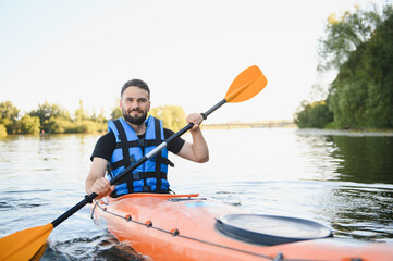 Kayaker paddling kayak on river in beautiful nature