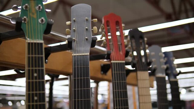 Different colored guitars and guitar strings. Hanging guitars. Musical instruments.