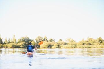 Fototapeta premium Kayaker paddling on calm lake enjoying water sports and active recreation