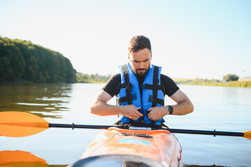 Kayaker wearing life jacket in kayak on lake or river