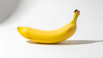 A ripe banana is placed on a white background, showcasing its vibrant yellow color and natural curves, ready to be enjoyed as a healthy snack.