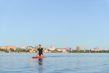 Man enjoying stand up paddleboarding on calm water