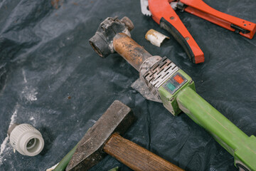 Equipment or plumbing work and soldering iron for PVC pipes. Hands using a soldering iron to join...