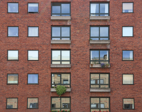 Part of a modern red brick apartment building with different types of windows(Copenhagen, Denmark)