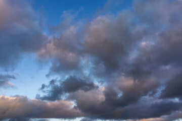 Colourful evening sky with dramatic clouds and patches of blue during sunset