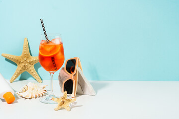 Summer alcohol cocktail drink and summer accessories at blue background. Aperol Spritz in wine...