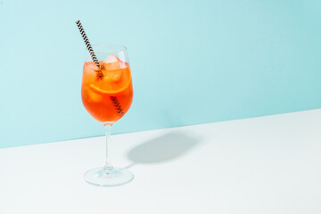 Aperol Spritz, traditional summer cocktail at blue background.