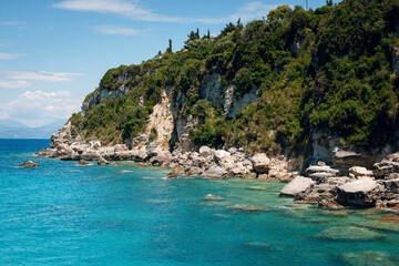 Fototapeta premium Rocky Cliffs and Turquoise Sea Under Clear Sky