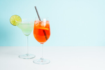 Margarita and Aperol Spritz at blue background.