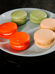 Colorful macarons arranged on a plate in a stylish setting