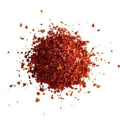 Rich red ground spice flakes scattered against black isolated on a transparent background paprika