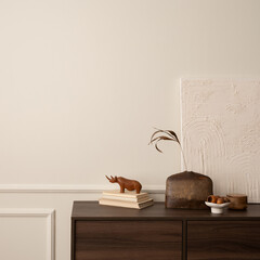 Creative composition of living room interior with mock up poster frame, copy space, wooden sideboard, vase with branch, books, stylish bowl, beige wall with stucco and personal accessories. 