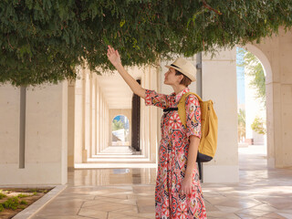 Young woman exploring Qasr Al Hosn Park in Abu Dhabi. Surrounded by lush greenery and historical...