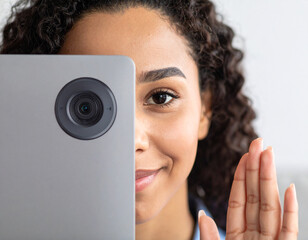 Teenager using privacy shutter on laptop webcam to ensure online safety while working on school assignments at home