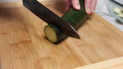 Chef slicing fresh zucchini on a bamboo cutting board, skillfully preparing ingredients for a nutritious meal in a bustling professional kitchen environment