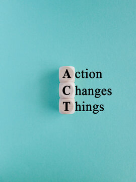 Wooden cubes with the letters A, C and T on beautiful blue background. Symbolizes the process of taking action to implement changes in various aspects of life or business.