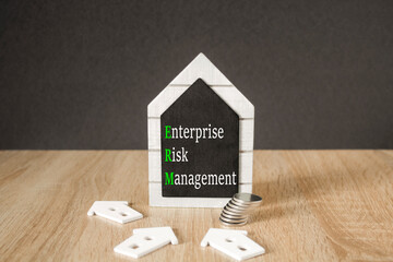 Concept words Enterprise Risk Management on black blackboard. Beautiful wooden table, black...