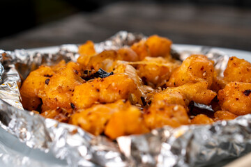 Crispy Shredded Chicken. Chinese Cuisine. A dish of meat. Appetizing chicken on a black background