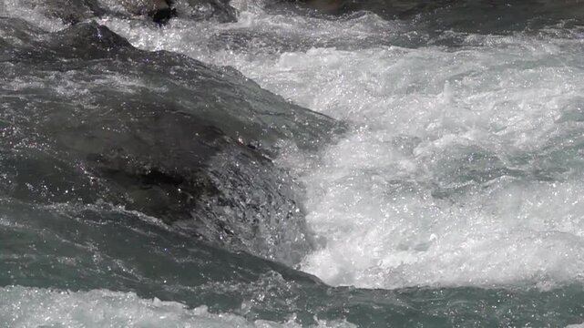 Vue rapproch&eacute;e au ralenti sur des courants rapides de rivi&egrave;re de montagne 