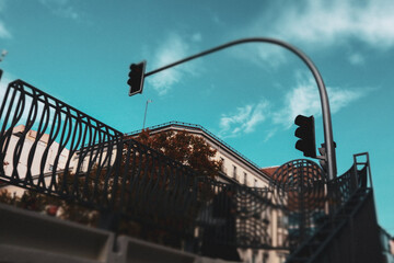 Traffic lights are seen above a building against a beautiful blue sky. An urban scene features...