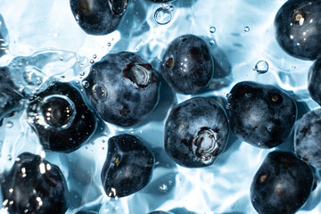 Berry background of fresh whole blueberries in water, splash of water, top view