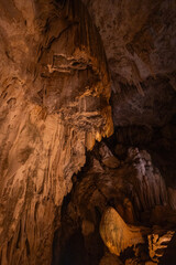 Visitors marvel at the intricate cave formations, illuminated by gentle lighting. The rocky...