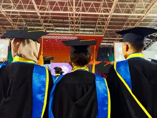 Students take part in the graduation procession wearing a toga set.