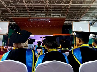Students take part in the graduation procession wearing a toga set.