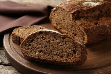 Pieces of fresh rye bread on wooden table, closeup