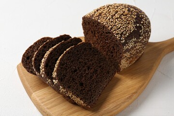 Pieces of fresh rye bread with seeds on white table, closeup