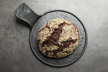 Fresh rye bread with seeds on grey table, top view