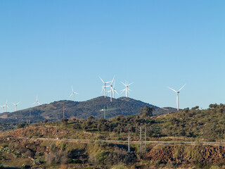 Clean energy solar panel and wind turbine in nature at sunset and city on background. for business...