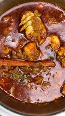 Aromatic crab meat and shrimp simmer in a rich brown sauce in a silver pot