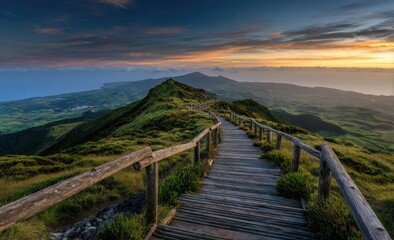 Fototapeta premium Winding wooden boardwalk ascends a verdant volcanic peak at sunset, overlooking a vast ocean vista