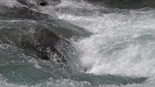 Vue rapproch&eacute;e au ralenti sur des courants rapides de rivi&egrave;re de montagne 