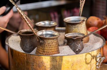 coffee being brewed in turks on hot sand at the bazaar, Garni, Armenia