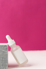 Transparent liquid product in glass bottle with dropper on purple background,Natural cosmetics concept,Cosmetic bottle with pipette