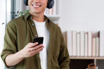 Work from Home: Smiling man checking smartphone while relaxing