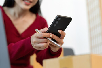 Remote Work: Woman Managing Deliveries with Smartphone and Pen