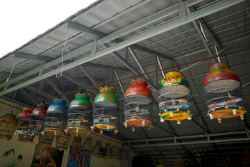 Colorful bird cages hanging on in front of the terrace of the house, in Yogyakarta, Indonesia