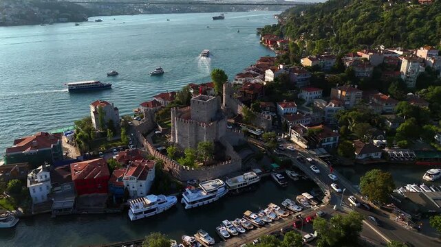 Drone footage of Anadolu Fortress on Istanbul&rsquo;s Asian side, featuring the historic castle, marina, coastal homes, boats, and Bosphorus scenery on a bright summer afternoon. Turkey Turkiye 4k