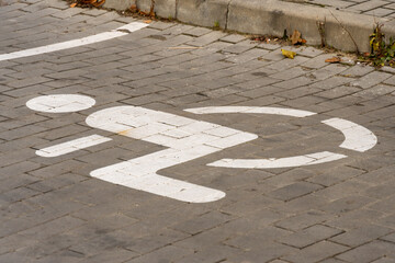 A parking space for individuals with disabilities features a clear symbol on the ground, located on...