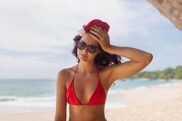 Frustrated Woman in Santa Hat and Bikini Standing on Tropical Beach Sand