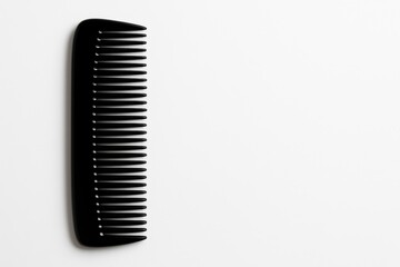 Minimalist black comb on white background with copy space. Perfect for grooming, beauty product ads, or minimalist branding visuals.
